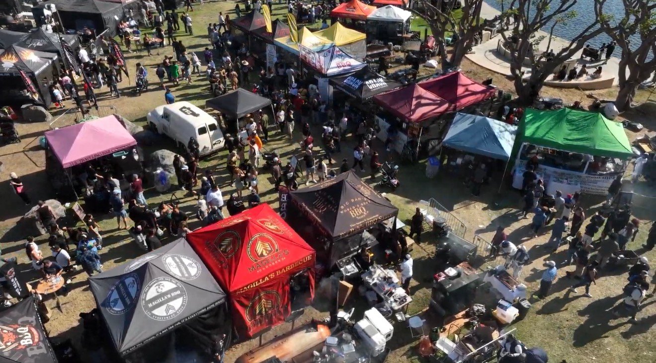 BBQ vendor village with colorful tents and crowds
